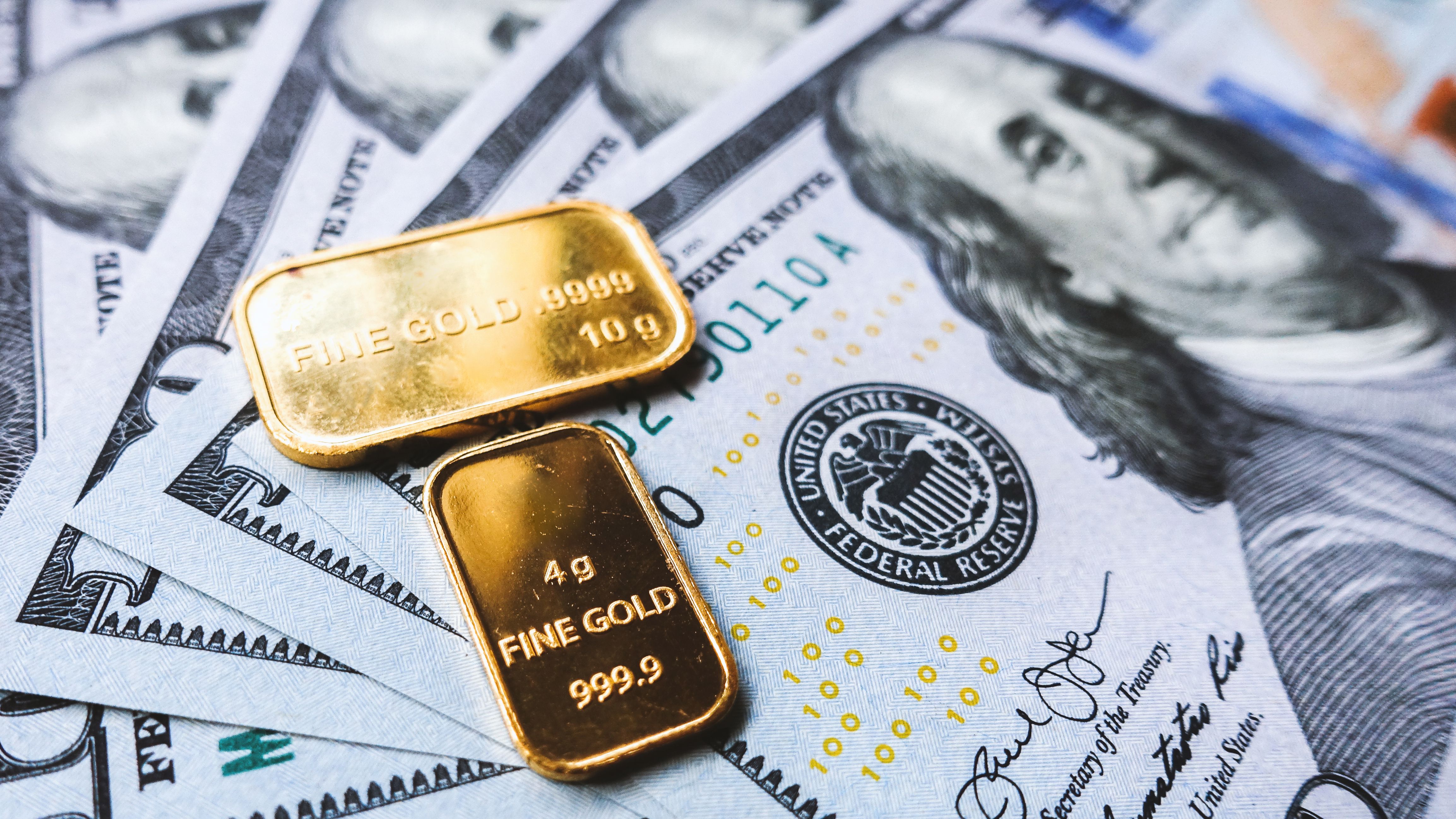 gold-bar-and-us-dollar-bills-2021-08-29-17-10-48-utc.jpg